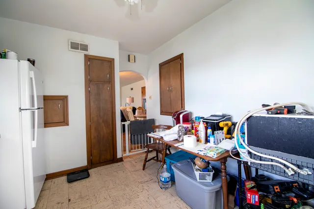 a reading room with furniture and a refrigerator