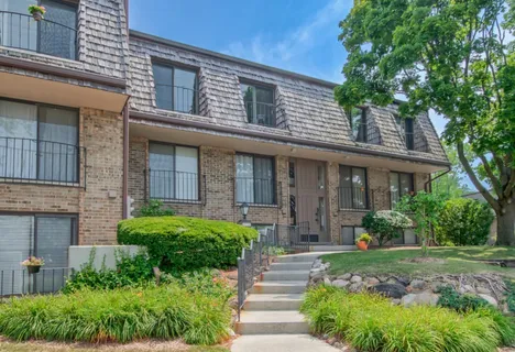 a front view of a house with yard and green space