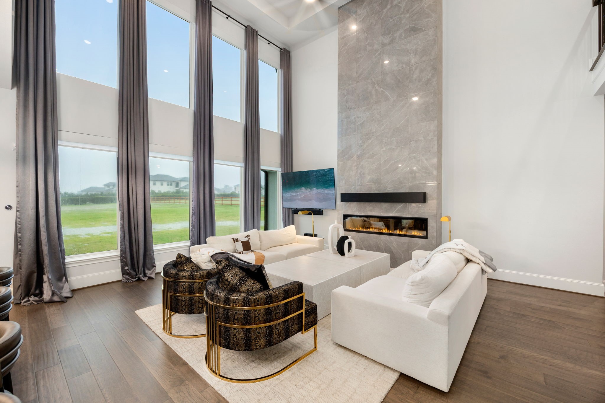 29419 Cir S Rnch Trail Fulshear, TX 77406 - Photo 10 of 45 The open-concept family room serves as a refined gathering space, equipped with continuous wood flooring, vast windows for natural light and a central fireplace layout.