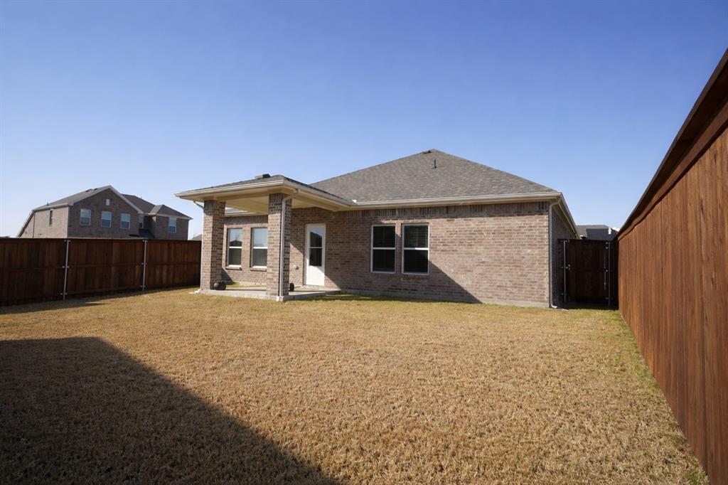 655 Scarlett Street Forney, TX 75126 - Photo 23 of 24 Back of house featuring brick siding, a patio, a fenced backyard, and roof with shingles