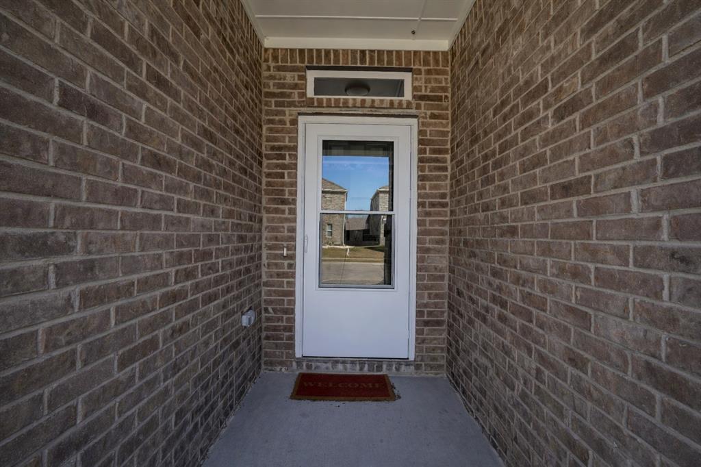 655 Scarlett Street Forney, TX 75126 - Photo 3 of 24 View of exterior entry with brick siding