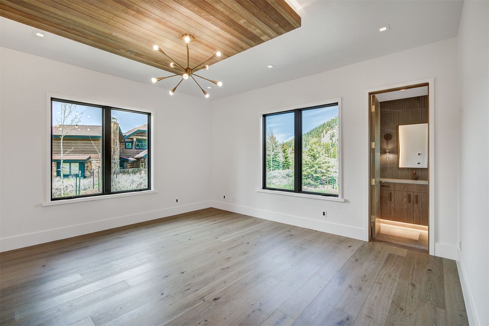 294 Gold Run Road Breckenridge, CO 80424 - Photo 33 of 49 an empty room with wooden floor chandelier and windows