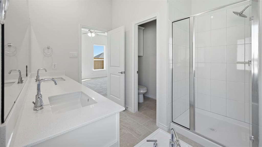 4163 Waldron Trail Forney, TX 75126 - Photo 15 of 30 Double vanity with integrated sinks, chrome faucets, and a white countertop