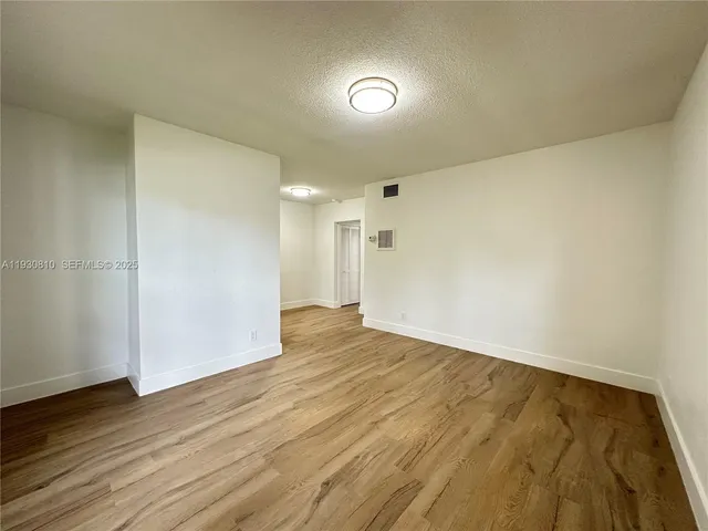 a view of an empty room and wooden floor