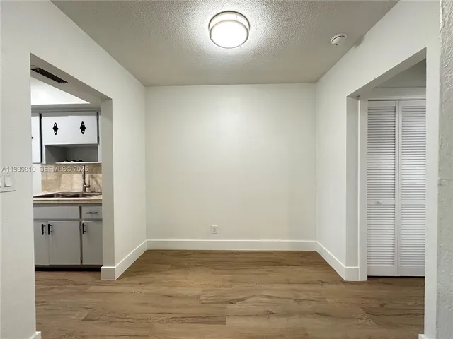 a view of a kitchen with a sink dishwasher and wooden floor
