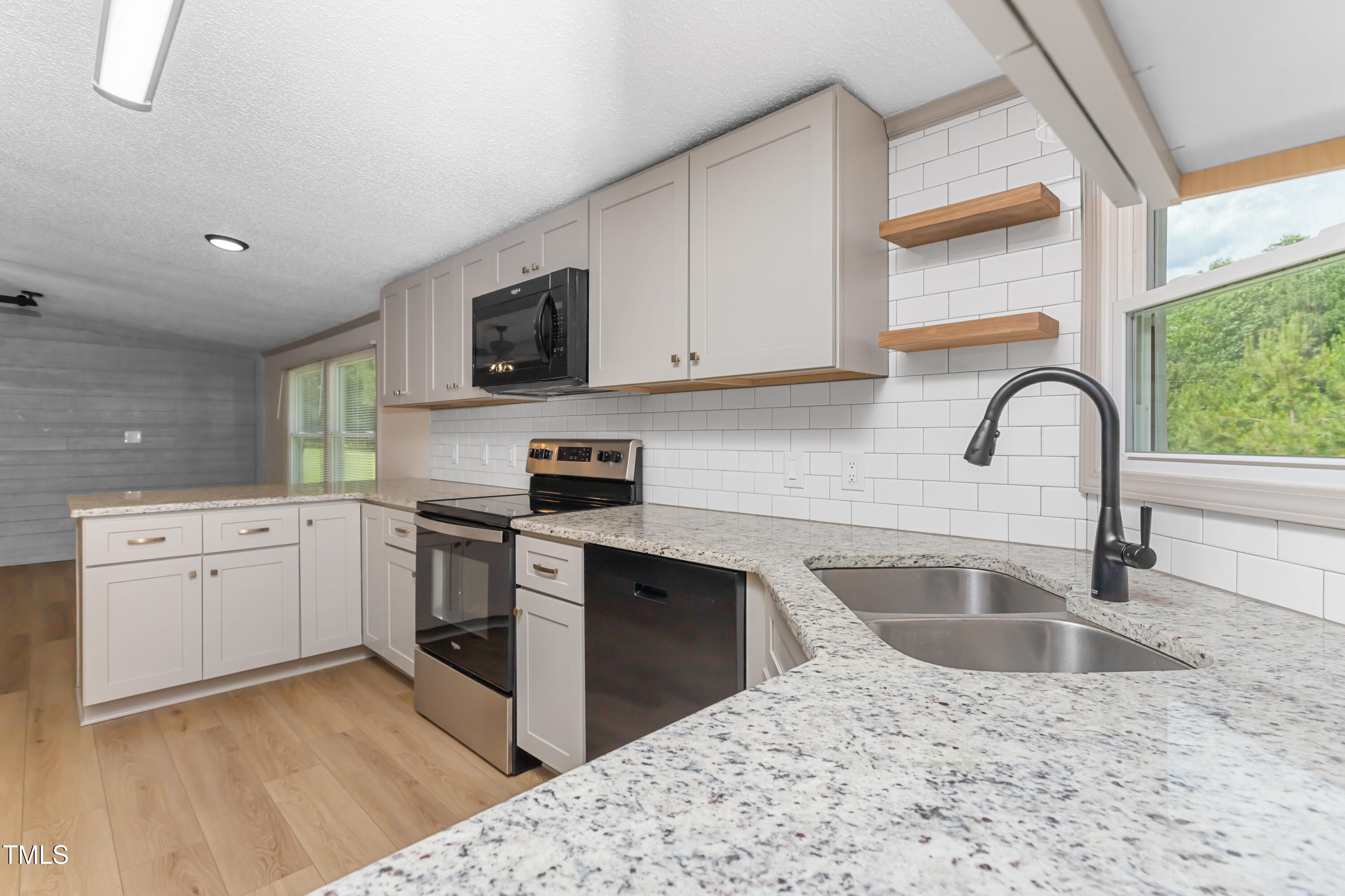 165 Dawn Road Benson, NC 27504 - Photo 11 of 30 a kitchen with granite countertop a sink a counter top space appliances and cabinets