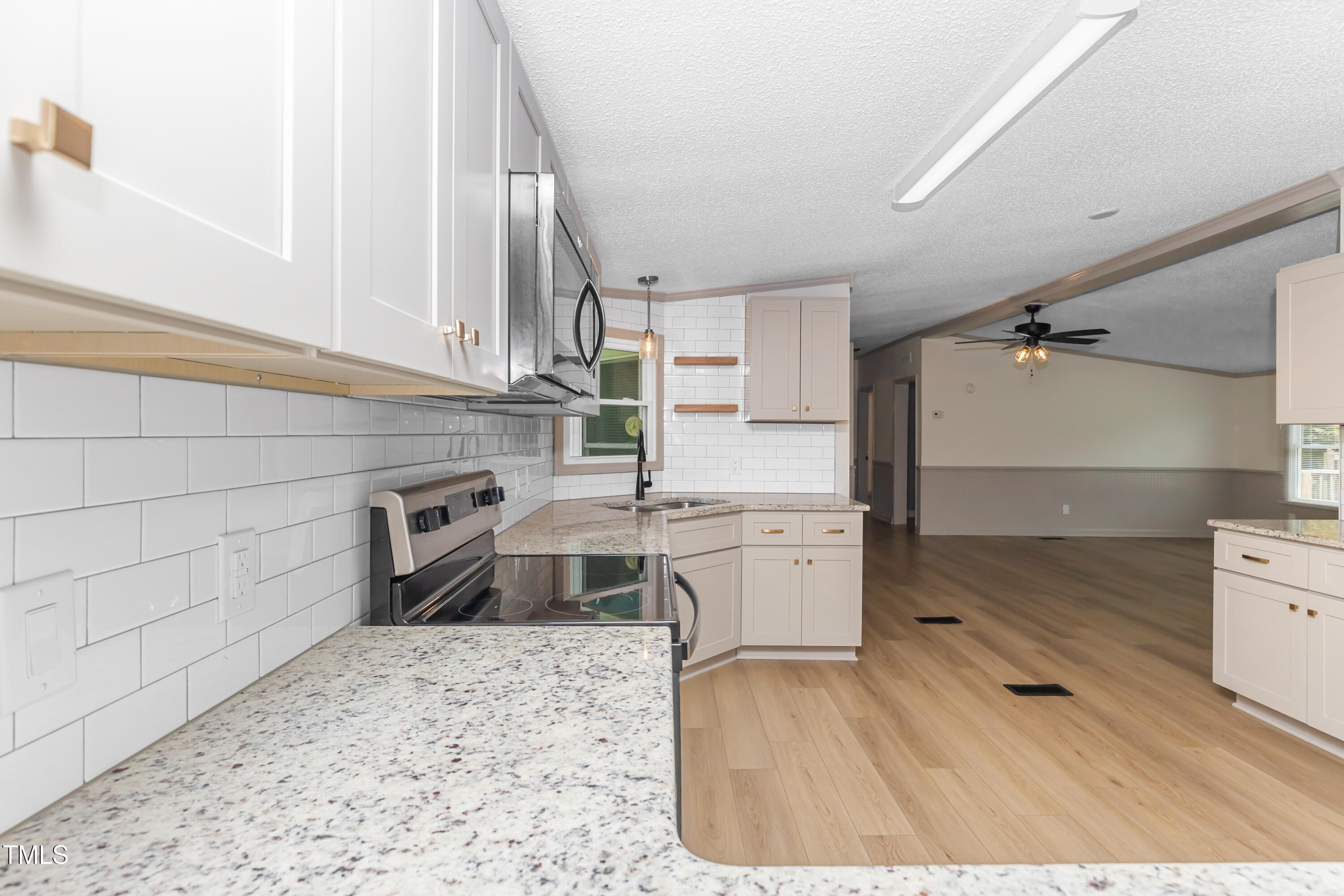165 Dawn Road Benson, NC 27504 - Photo 10 of 30 a kitchen with granite countertop a stove a sink and a refrigerator