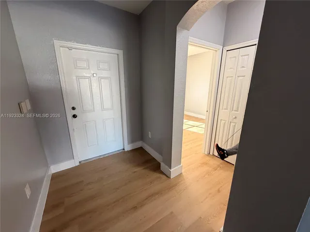 an empty room with wooden floor and a window