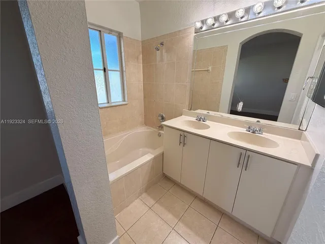 a bathroom with a tub sink and mirror
