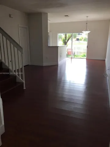 an empty room with wooden floor and a window