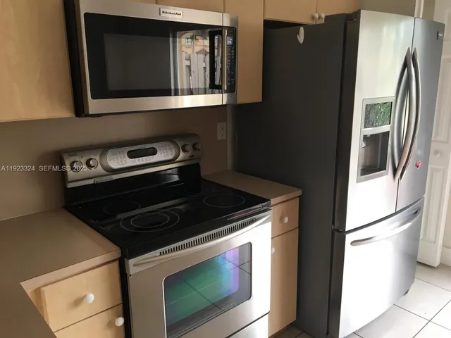 a kitchen with granite countertop white cabinets and stainless steel appliances