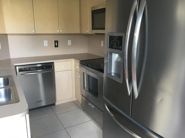 a kitchen with stainless steel appliances a refrigerator sink and stove