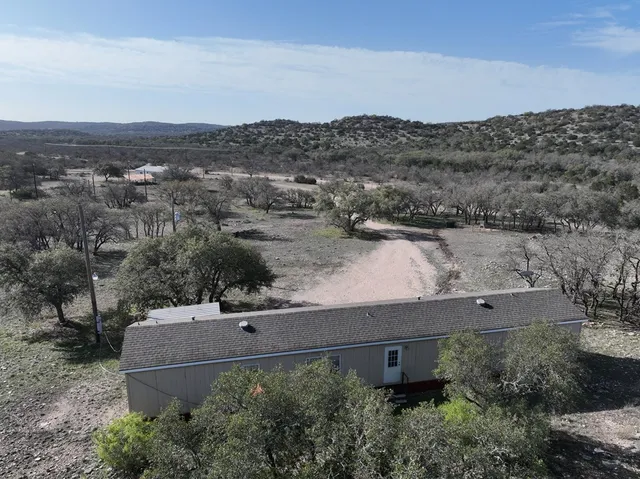 an aerial view of a house with a yard and lake view