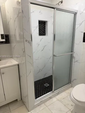 a bathroom with a toilet a sink and mirror