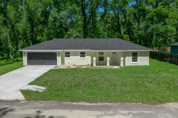 a aerial view of a house next to a yard