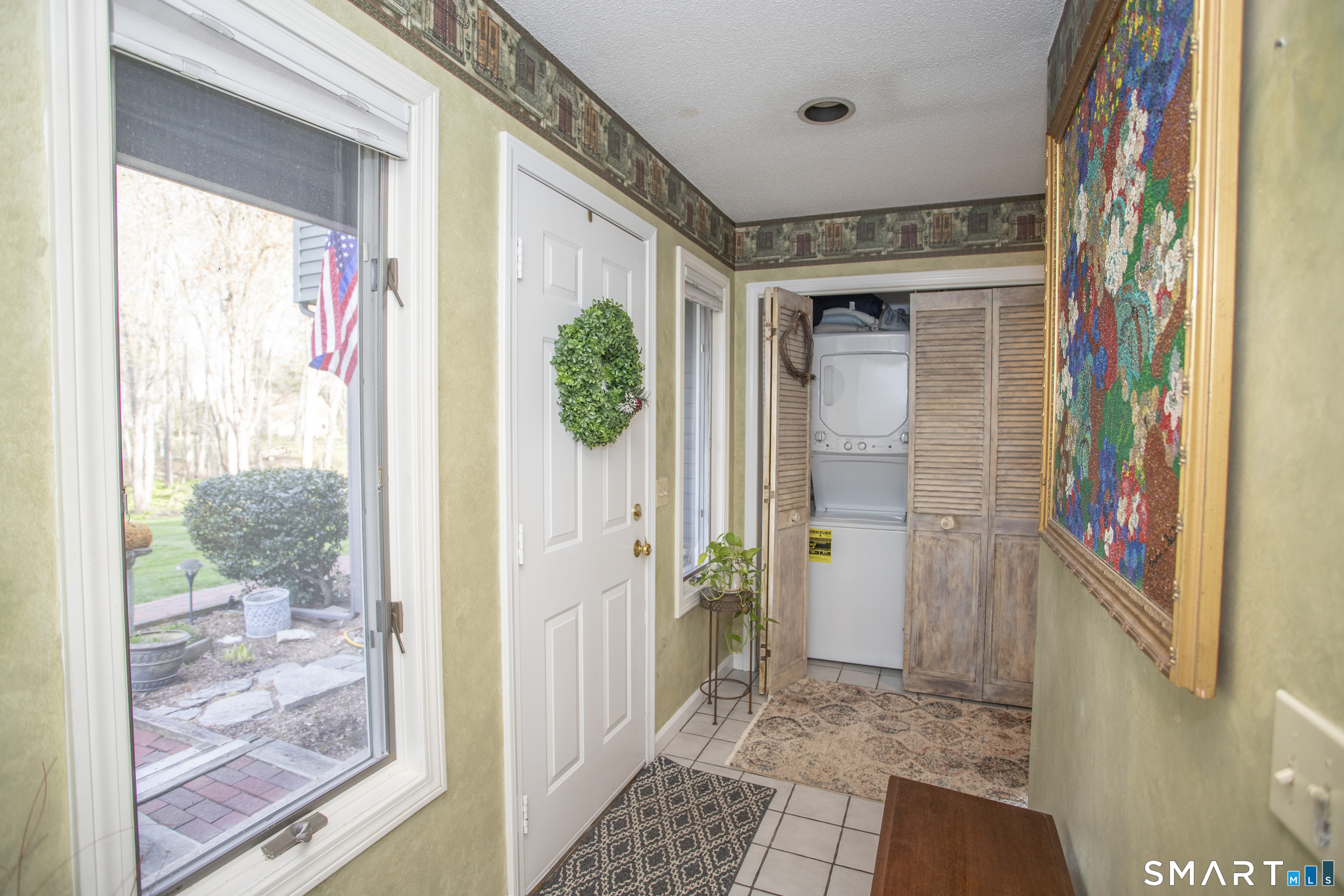 115 Ayers Point Road Old Saybrook, CT 06475 - Photo 18 of 34 a view of a hallway with wooden floor and a dining room with a door and a window