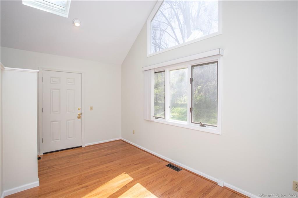 115 Ayers Point Road Old Saybrook, CT 06475 - Photo 24 of 34 an empty room with wooden floor and windows