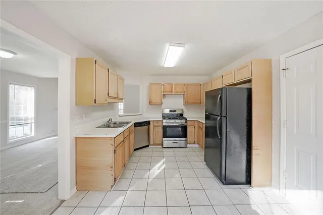 a kitchen with a refrigerator sink and cabinets