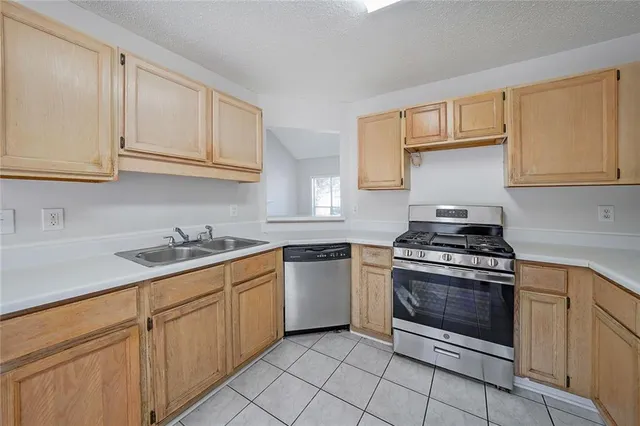 a kitchen with granite countertop white cabinets and stainless steel appliances
