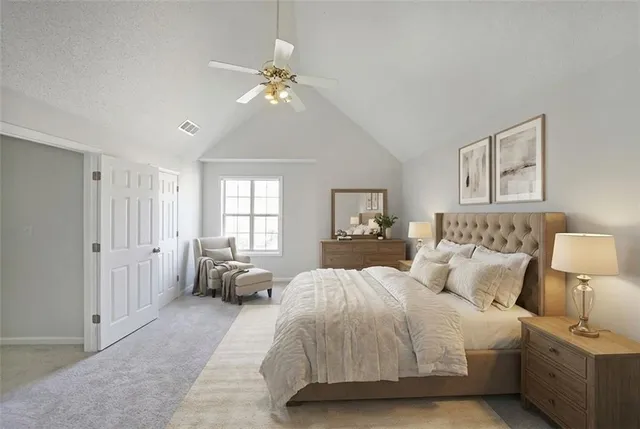 a spacious bedroom with a bed and a chandelier