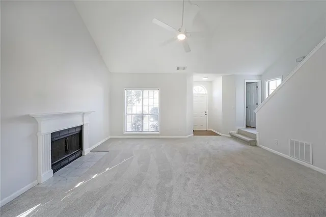 an empty room with windows and fireplace