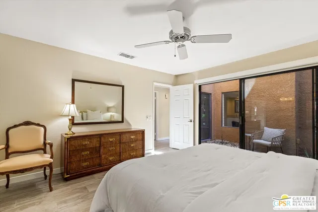 a bedroom with a bed and a dresser with mirror