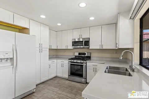 a kitchen with stainless steel appliances granite countertop a refrigerator sink and stove