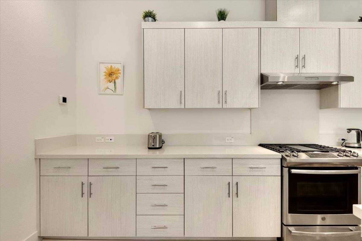 7961 Regional Common Dublin, CA 94568 - Photo 9 of 40 a kitchen with granite countertop white cabinets and white appliances