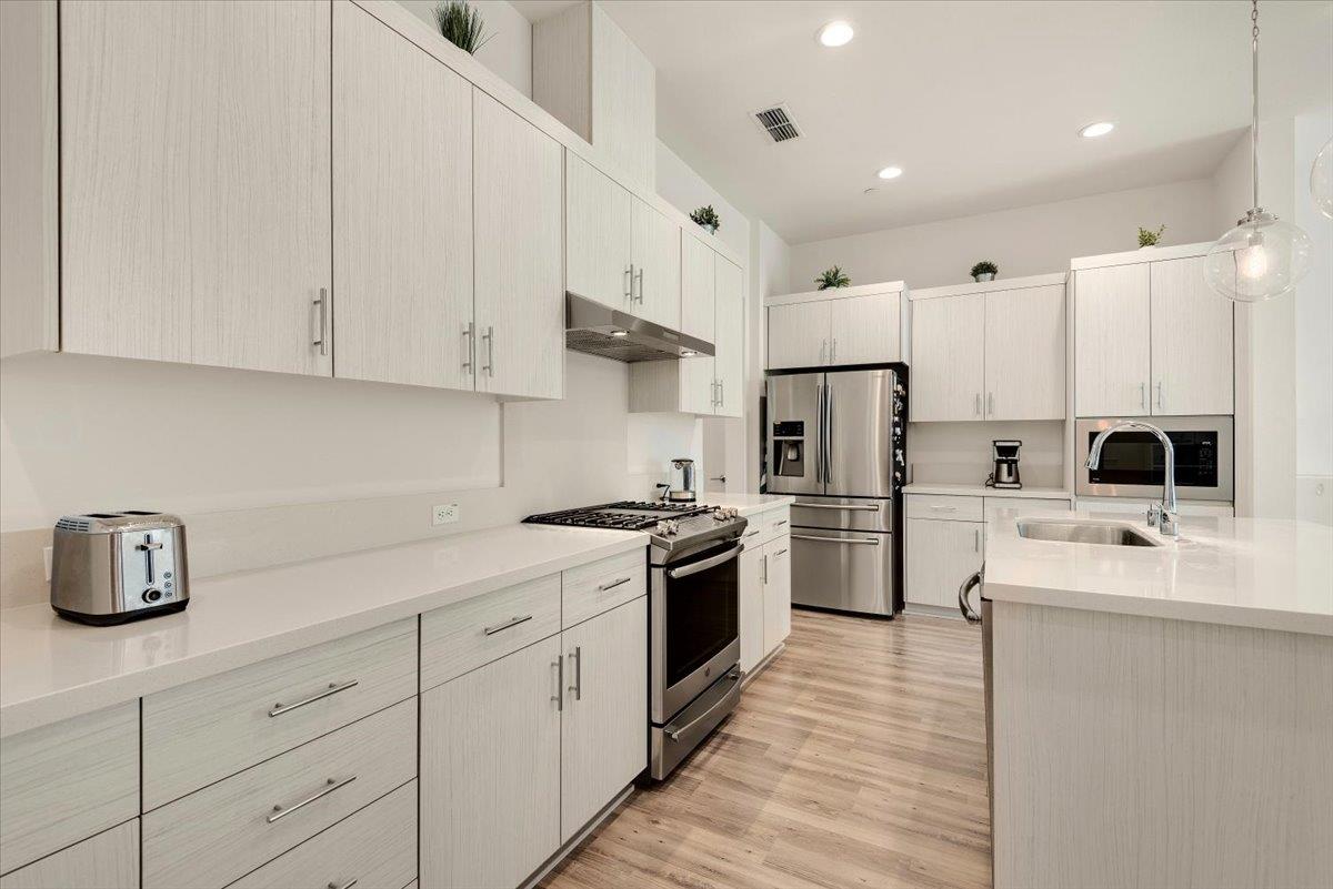 7961 Regional Common Dublin, CA 94568 - Photo 10 of 40 a kitchen with white cabinets and stainless steel appliances
