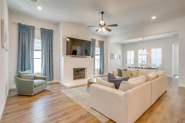 a living room with furniture a flat screen tv and a fireplace