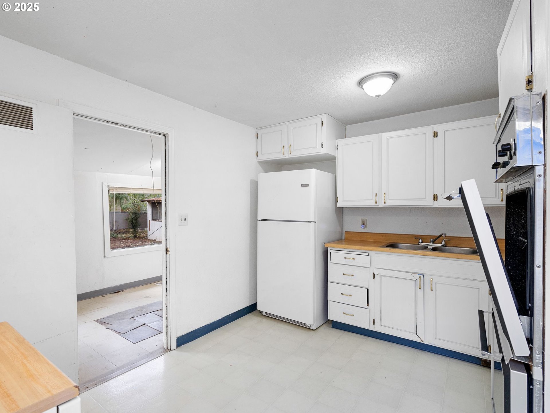 6009 Southeast 138th Place Portland, OR 97236 - Photo 16 of 37 a kitchen with granite countertop a refrigerator a stove a sink a washer and dryer