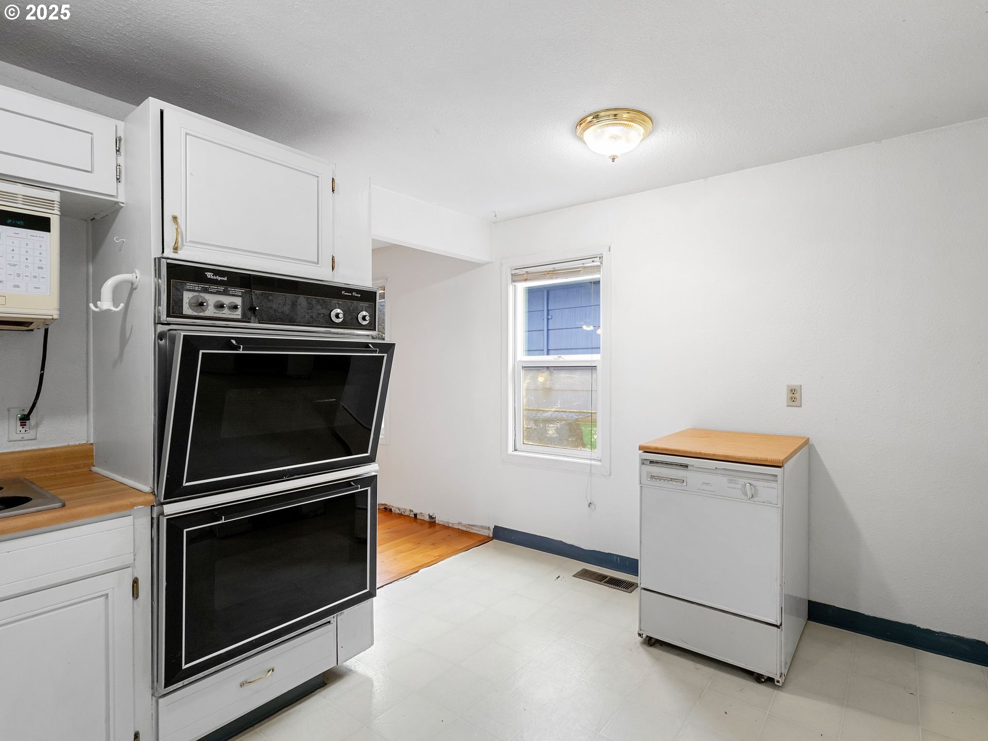 6009 Southeast 138th Place Portland, OR 97236 - Photo 17 of 37 a kitchen with granite countertop white cabinets and appliances