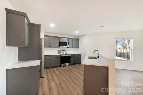 a large room with a large window and stainless steel appliances