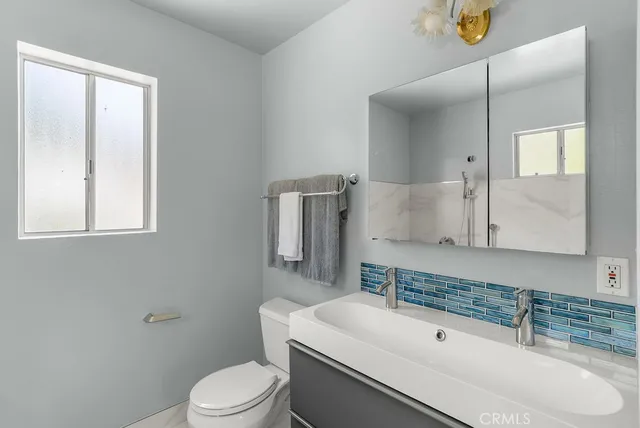 a bathroom with a granite countertop tub a sink and a window