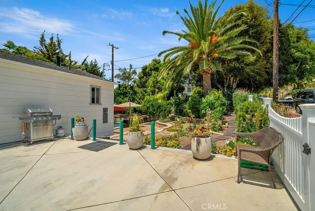 a view of backyard with seating space and wooden fence