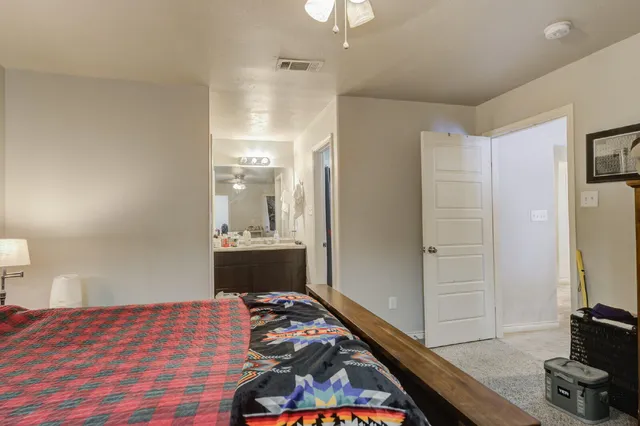 a bedroom with a bed and a mirror on the dresser