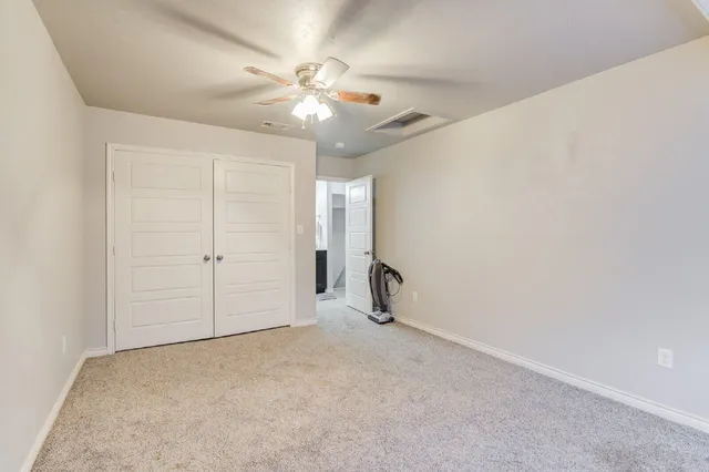 an empty room with a view of a chandelier fan