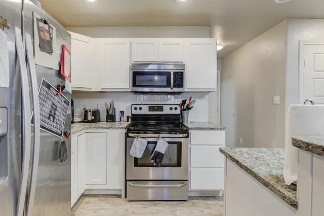 a kitchen with stainless steel appliances granite countertop a stove and a refrigerator