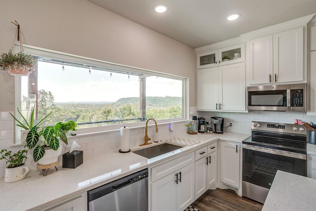 9720 Scenic View Court Rio Vista, TX 76093 - Photo 11 of 31 a kitchen with a sink a stove and a microwave