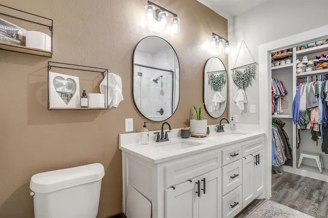 a bathroom with a granite countertop sink a toilet and shower
