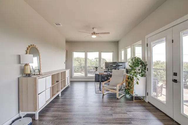a dining room with wooden floor and a floor to ceiling window