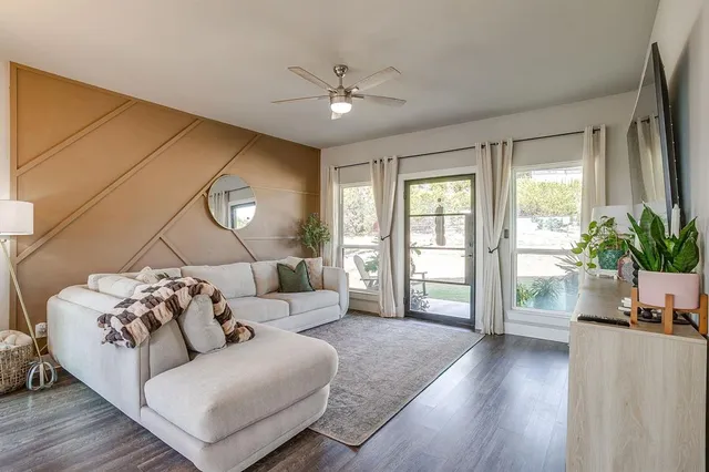 a living room with furniture kitchen view and a chandelier