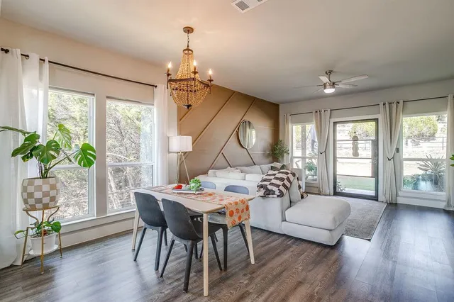 a large white kitchen with a large island oven a sink dishwasher and white cabinets with wooden floor