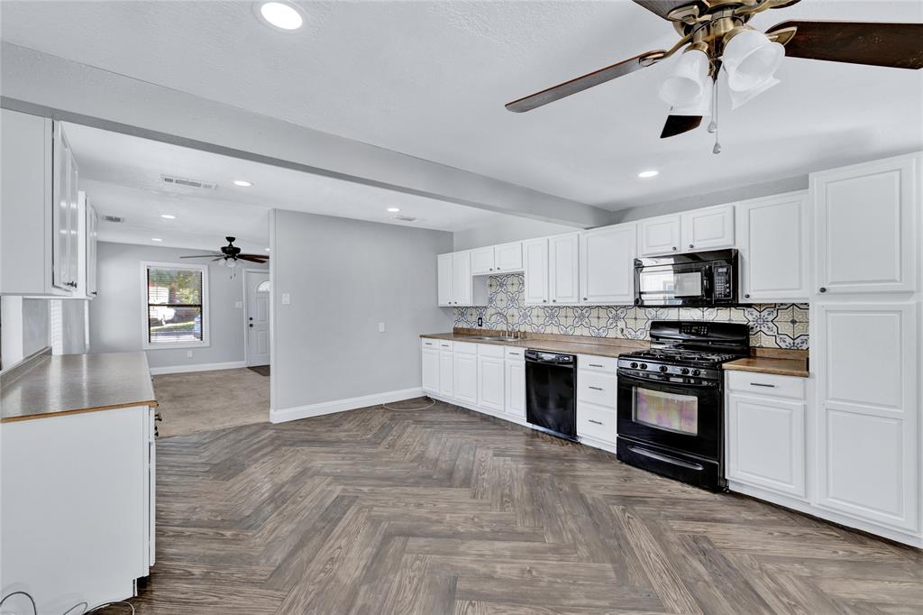 4120 Fry Street Fort Worth, TX 76115 - Photo 7 of 29 Kitchen with ceiling fan, white cabinets, black appliances, decorative backsplash, and recessed lighting