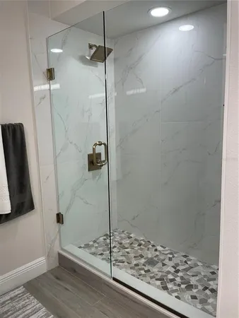 a bathroom with a shower and a wooden floor