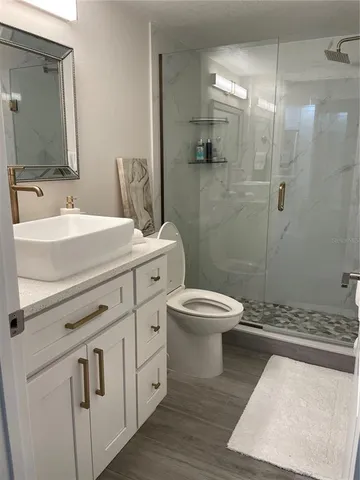 a bathroom with a sink a toilet and shower