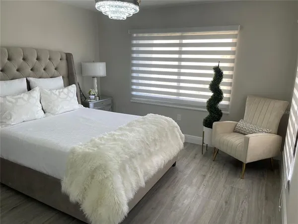 a bedroom with bed and a couch with window