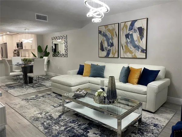a living room with furniture flowerpot and wooden floor
