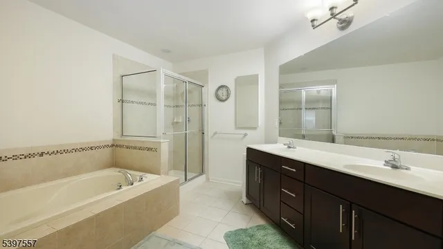 a bathroom with a tub a sink shower and mirror