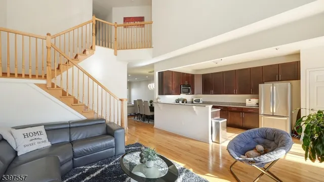 a living room with furniture kitchen and a wooden floor